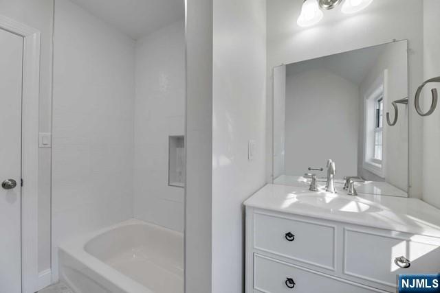 401 Franklin Street, Unit 2 Bloomfield, NJ 07003 - Photo 12 of 13 a bathroom with a bathtub sink vanity and mirror