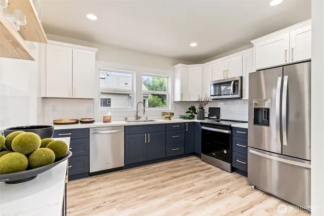 a kitchen with stainless steel appliances granite countertop a refrigerator sink and stove