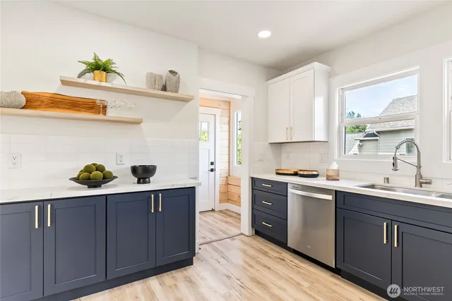 a kitchen with a sink a stove cabinets and wooden floor