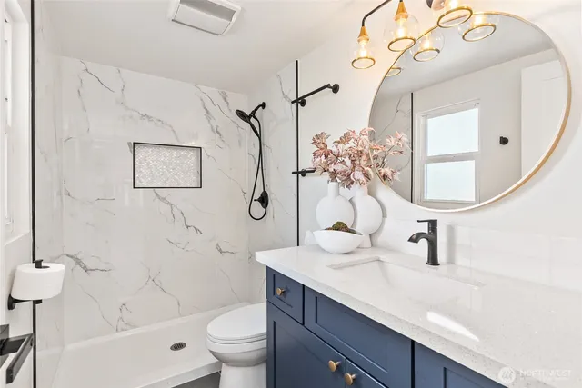 a bathroom with a sink a toilet and a mirror