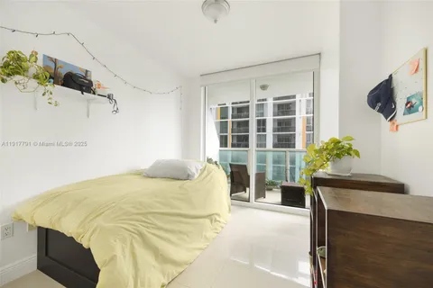 a bed sitting in a spacious bedroom next to a window