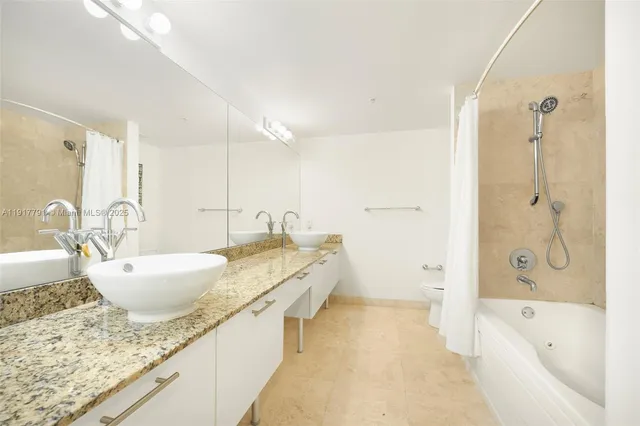 a bathroom with a granite countertop tub sink and mirror