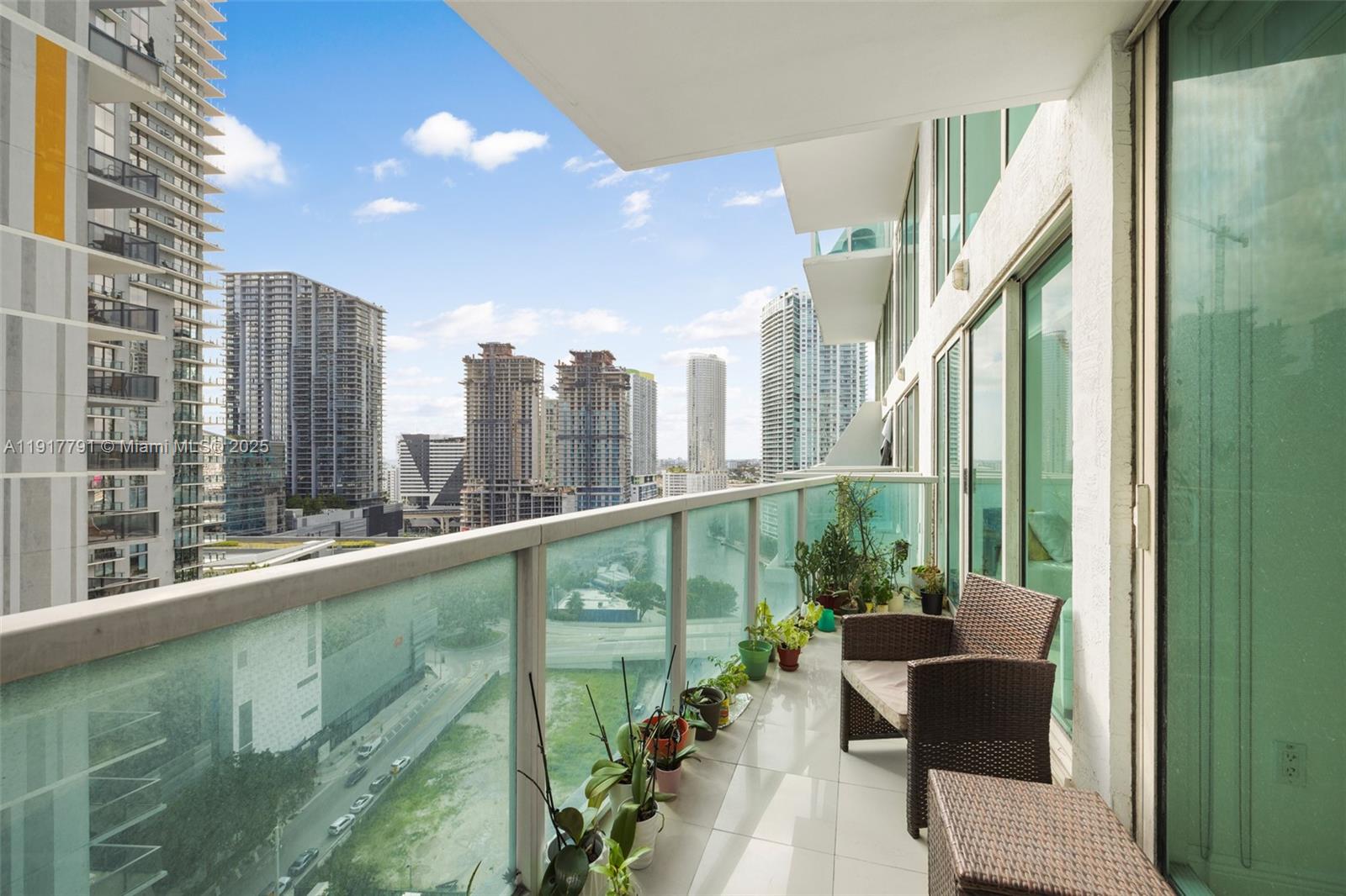 41 Southeast 5th Street, Unit 1210 Miami, FL 33131 - Photo 3 of 15 a view of a balcony with chairs and a potted plant