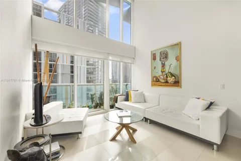 a living room with furniture and a floor to ceiling window