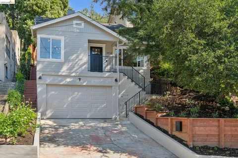 a view of a house with a yard and potted plants