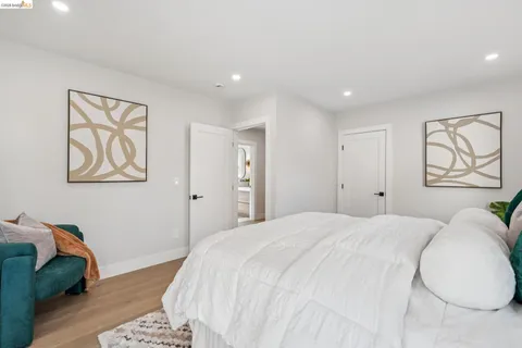 a bedroom with a bed and a painting on the wall