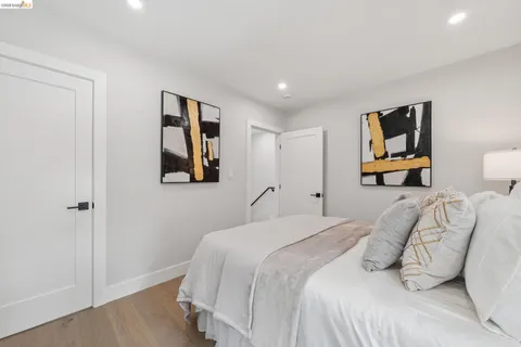a bedroom with a large bed and a painting on the wall