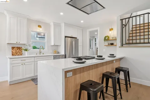 a kitchen that has a sink a stove counter top space and cabinets