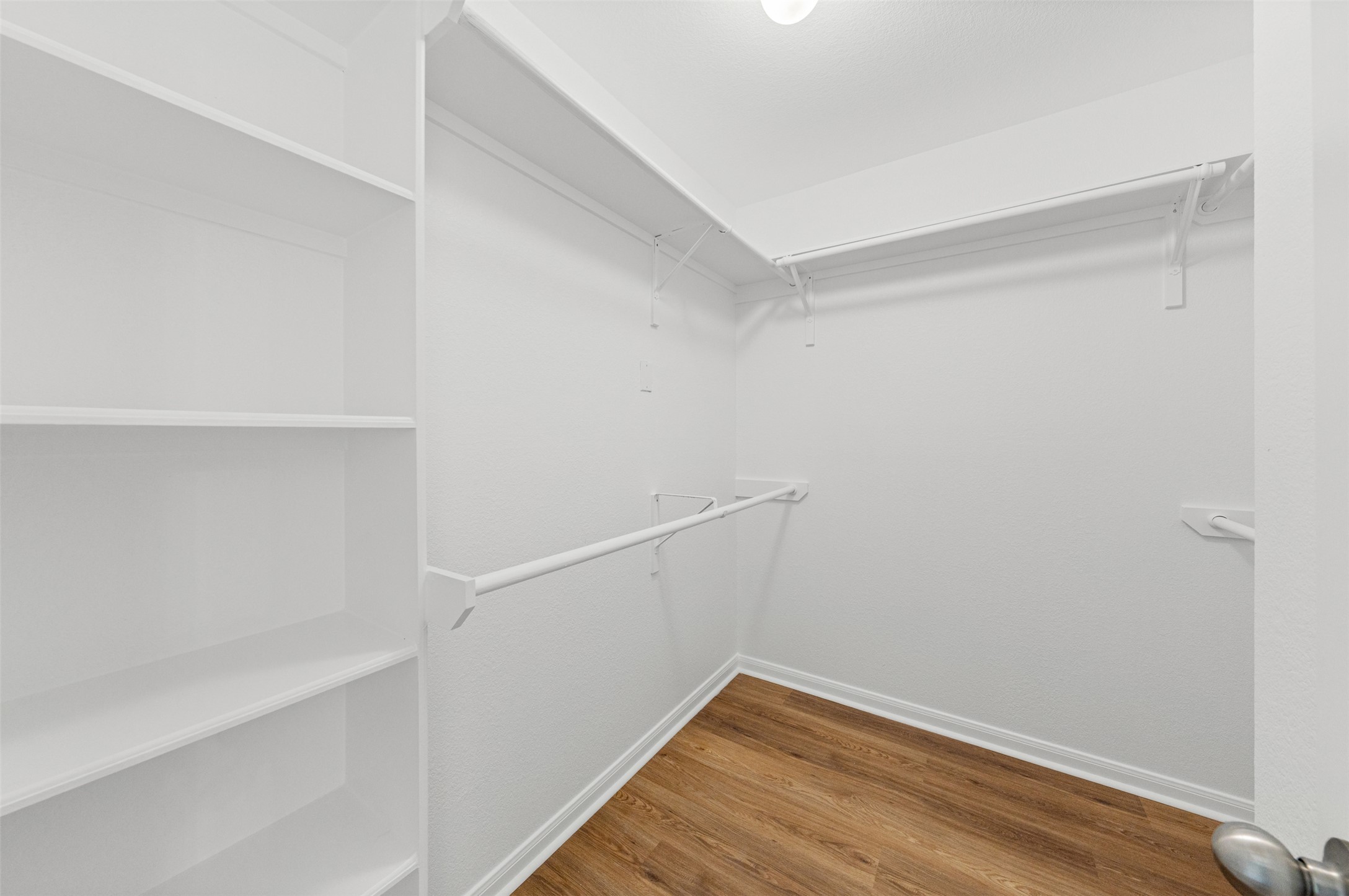 243 Engineers Pass Jarrell, TX 76537 - Photo 26 of 40 Walk-in closet featuring built-in shelving, two hanging rods, and wood-finish flooring