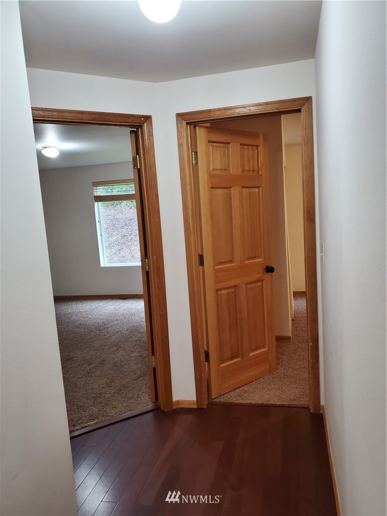 541 East Coulter Creek Road Belfair, WA 98528 - Photo 27 of 39 an empty room with wooden floor and a fireplace