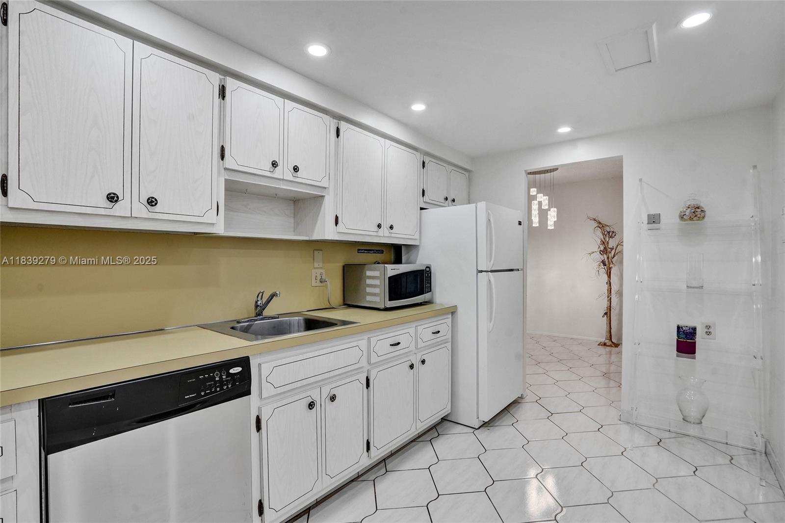 405 North Ocean Boulevard, Unit 815 Pompano Beach, FL 33062 - Photo 14 of 41 a kitchen with white cabinets and white appliances