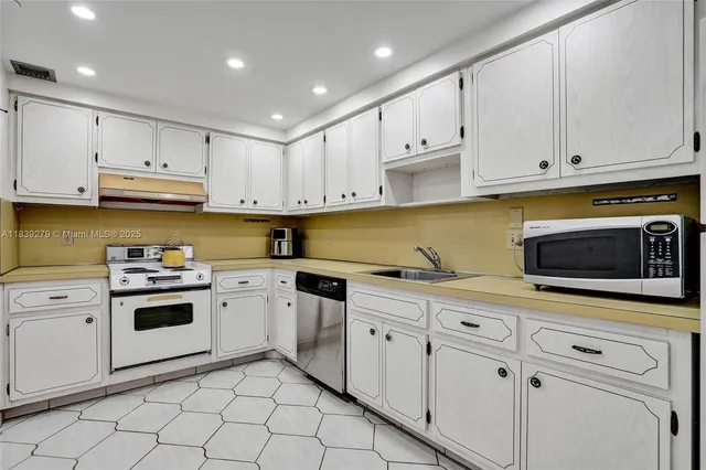 a kitchen with white cabinets and stainless steel appliances