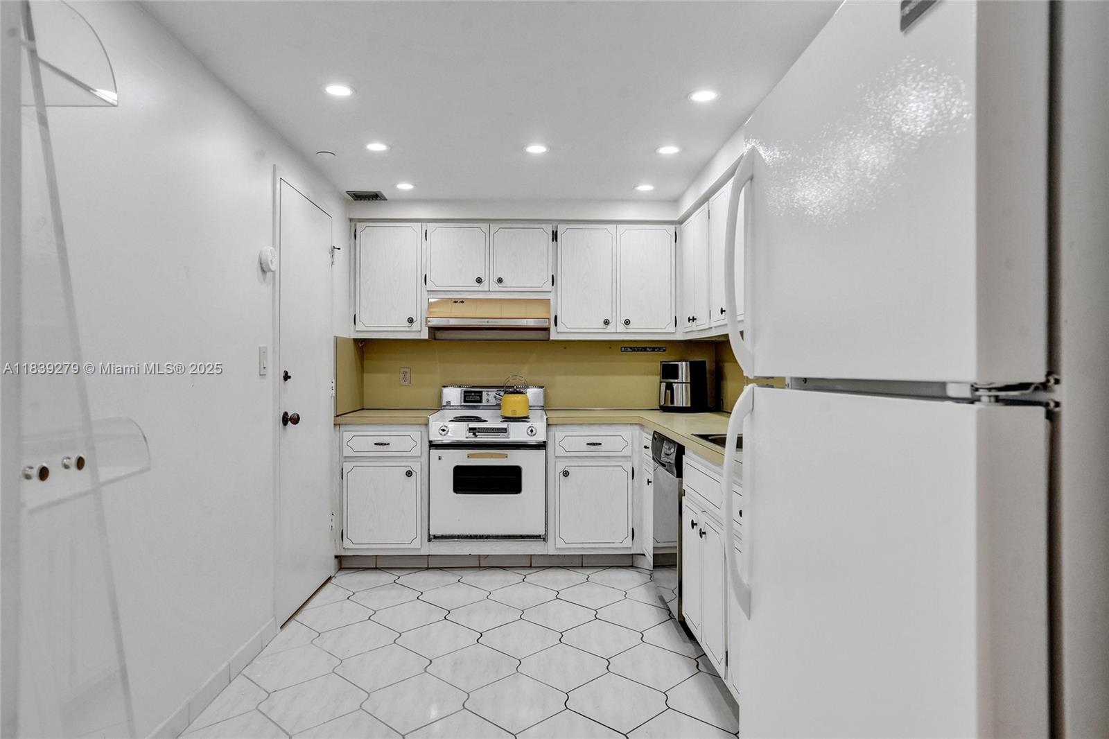 405 North Ocean Boulevard, Unit 815 Pompano Beach, FL 33062 - Photo 20 of 41 a kitchen with white cabinets and stainless steel appliances