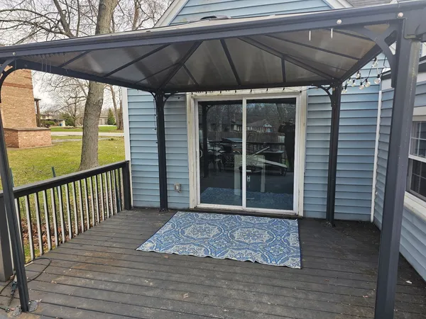 a view of a porch with wooden floor and a yard