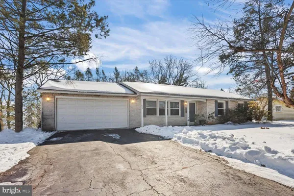a front view of house with yard covered in snow