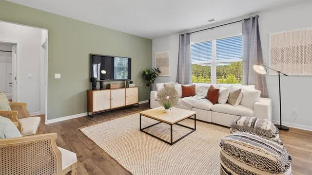 a living room with furniture a flat screen tv and a floor to ceiling window