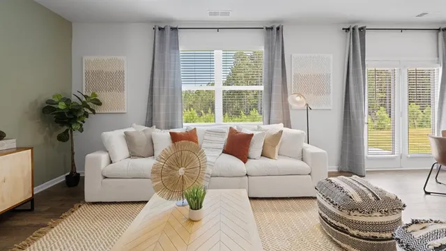 a living room with furniture wooden floor and a large window