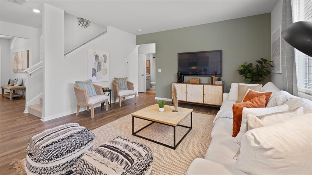 5541 Donamire Way Fairburn, GA 30213 - Photo 15 of 71 a living room with furniture a flat screen tv and a floor to ceiling window