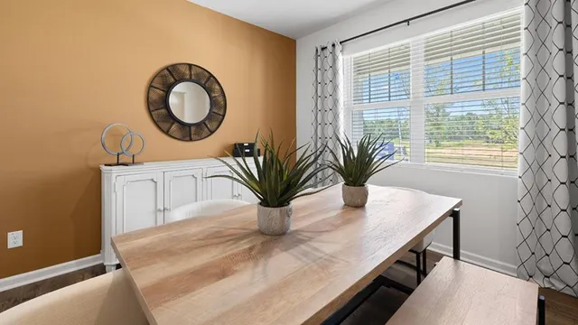 a kitchen with stainless steel appliances a table chairs refrigerator and microwave