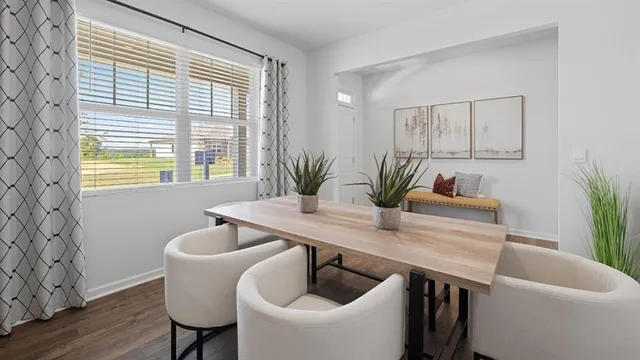a kitchen with granite countertop a dining table chairs and a refrigerator