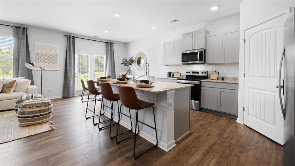 5541 Donamire Way Fairburn, GA 30213 - Photo 6 of 71 a kitchen with stainless steel appliances a table chairs refrigerator and microwave