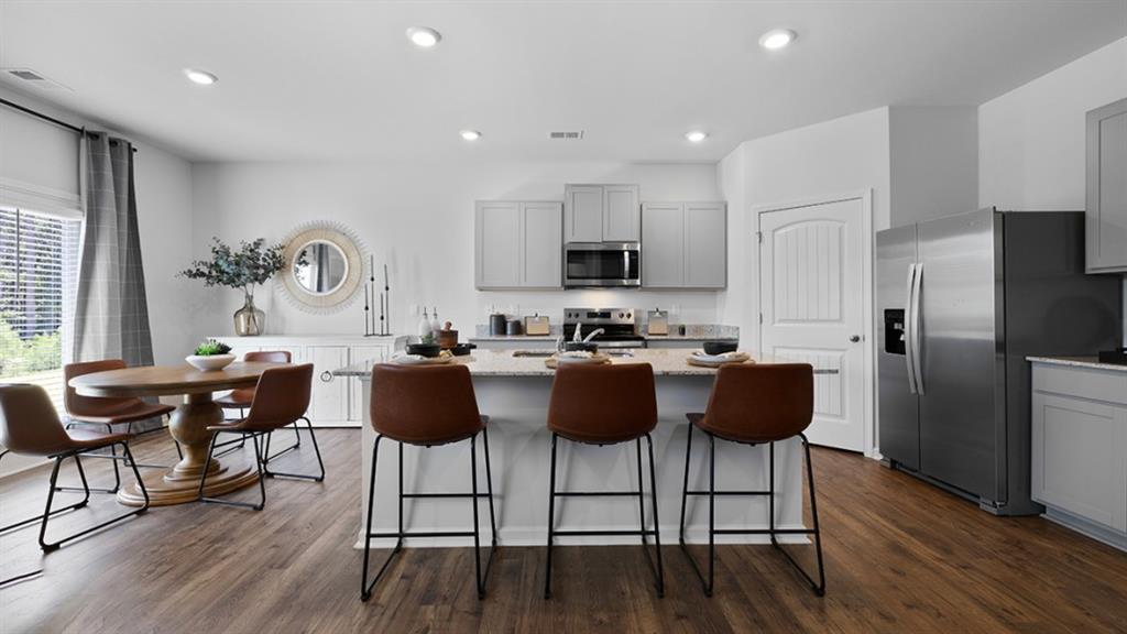 5541 Donamire Way Fairburn, GA 30213 - Photo 7 of 71 a kitchen with granite countertop a dining table chairs and a refrigerator