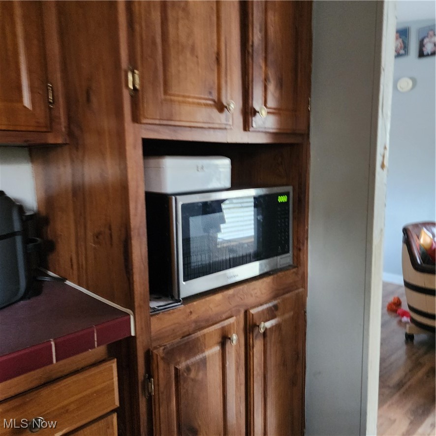 6487 Klass Road Cambridge, OH 43725 - Photo 7 of 20 Kitchen featuring brown cabinets, stainless steel microwave, and wood finished floors