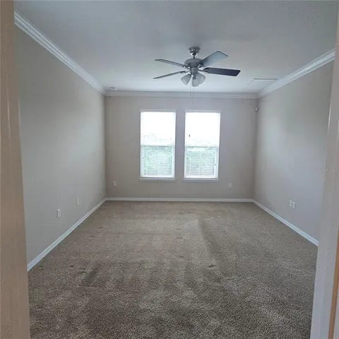 an empty room with a window and a fan