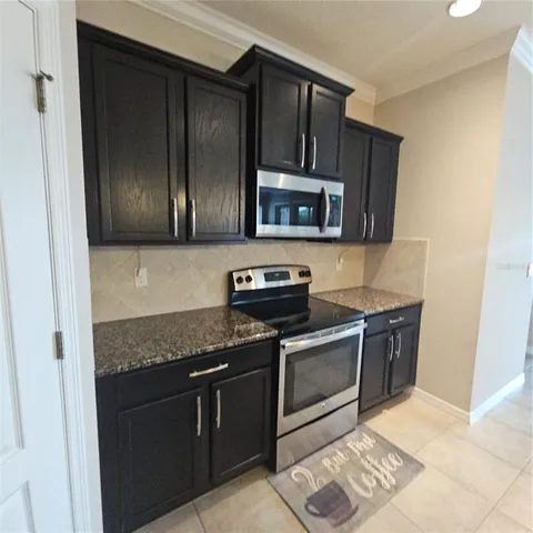a kitchen with granite countertop wooden cabinets and stainless steel appliances
