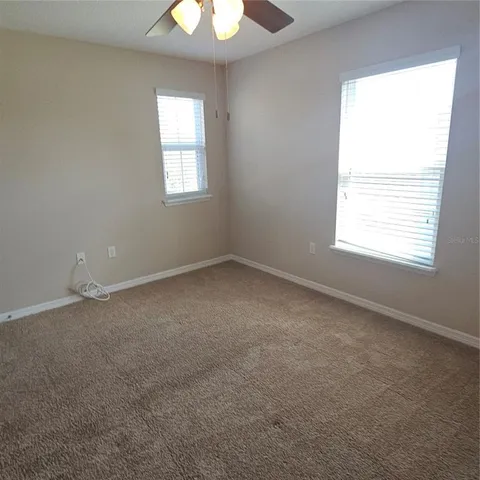 an empty room with a window and a fan