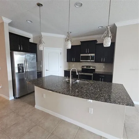 a kitchen with stainless steel appliances granite countertop a sink a refrigerator and a granite counter tops