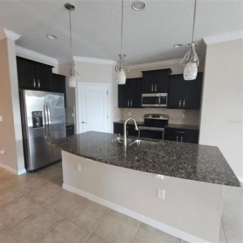 a kitchen with stainless steel appliances granite countertop a sink a refrigerator and a granite counter tops