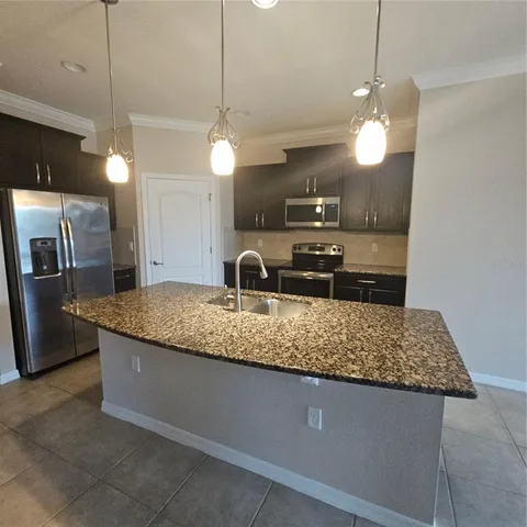 a large kitchen with kitchen island a counter space a sink and appliances