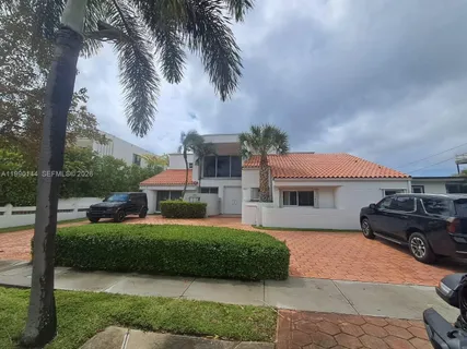 a front view of a house with a garden and trees