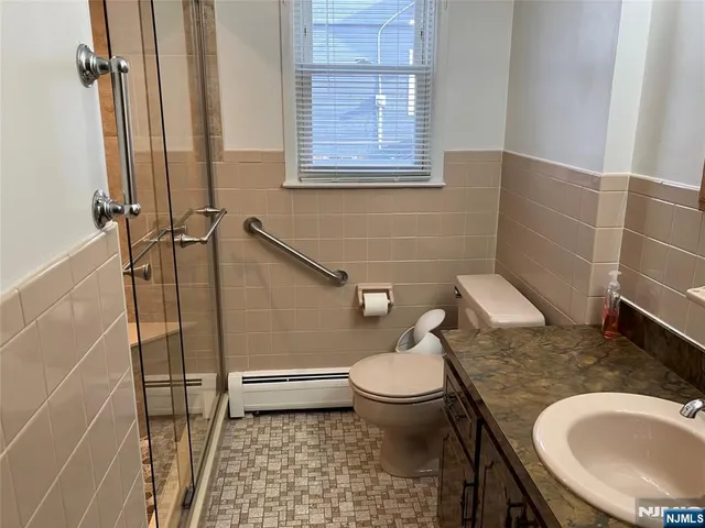 a bathroom with a granite countertop toilet sink and mirror