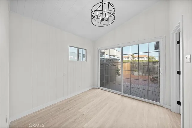 an empty room with wooden floor and mirror