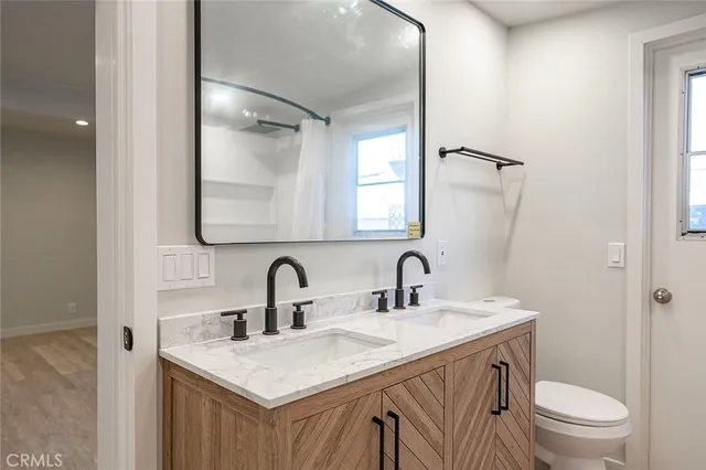 a bathroom with a granite countertop sink toilet and shower