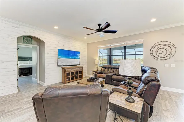 a living room with furniture ceiling fan and a flat screen tv