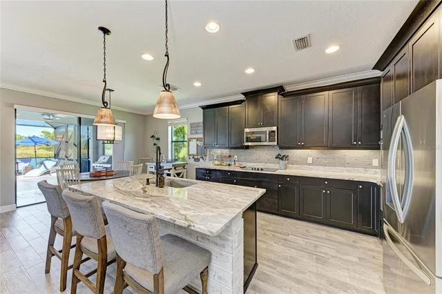 a kitchen with stainless steel appliances granite countertop a sink a stove and a wooden floors