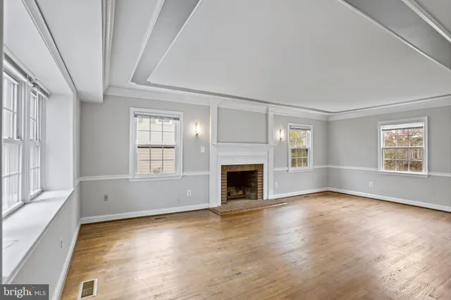 a view of empty room with wooden floor and fireplace
