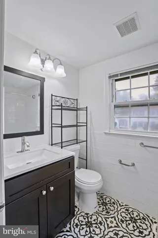 a bathroom with a sink toilet and window
