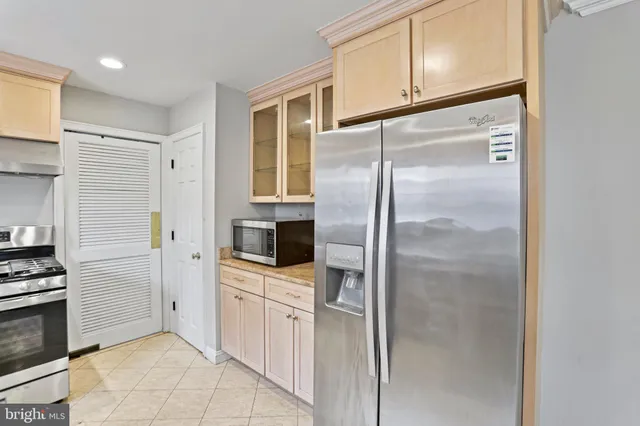 a kitchen with white cabinets and refrigerator