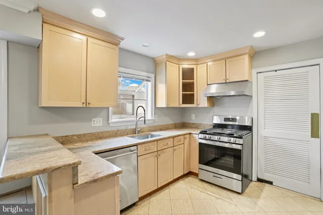 a kitchen with stainless steel appliances granite countertop a sink stove and cabinets