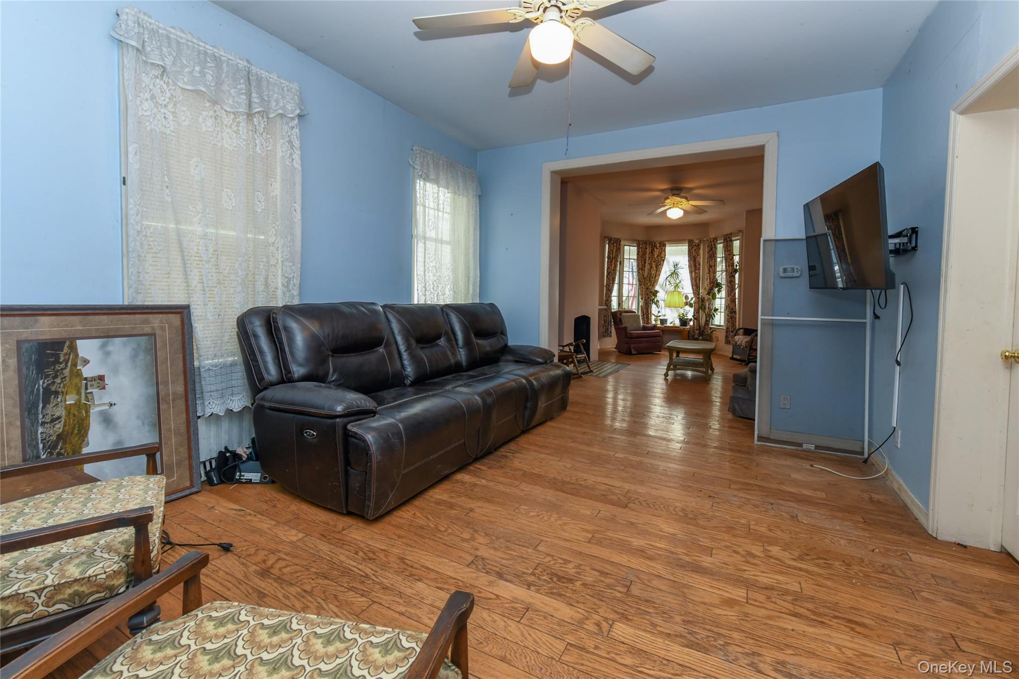 76-43 85th Road Queens, NY 11421 - Photo 12 of 31 a living room with furniture and a chandelier