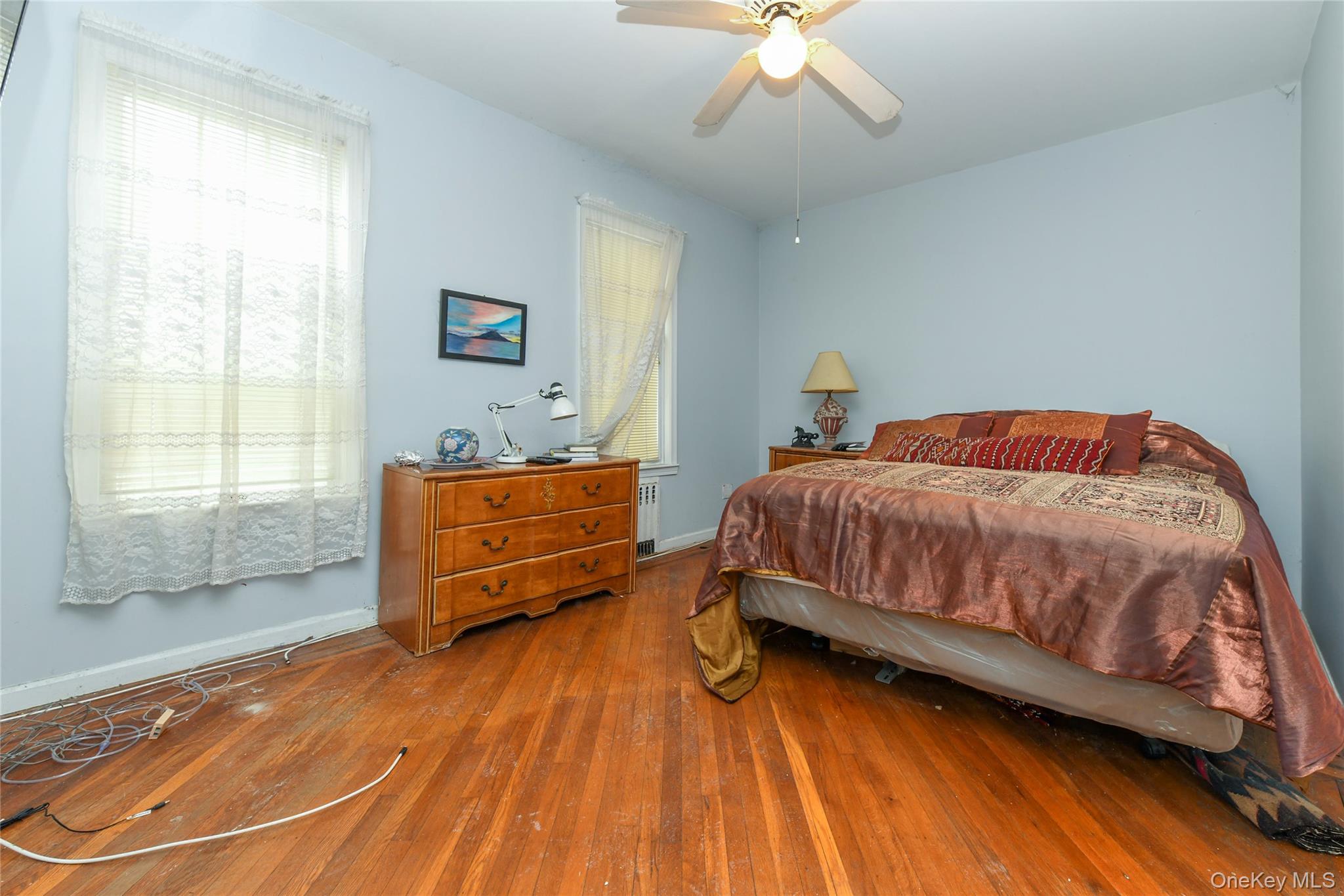 76-43 85th Road Queens, NY 11421 - Photo 16 of 31 a bedroom with a bed and wooden floor