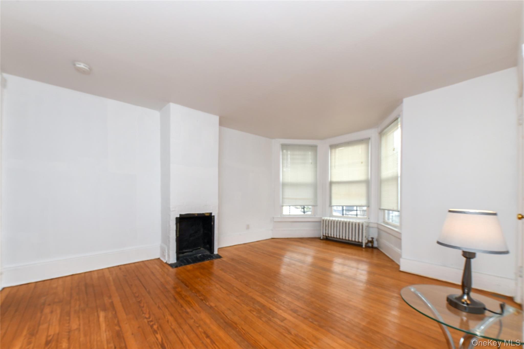 76-43 85th Road Queens, NY 11421 - Photo 21 of 31 a view of empty room with wooden floor and fan