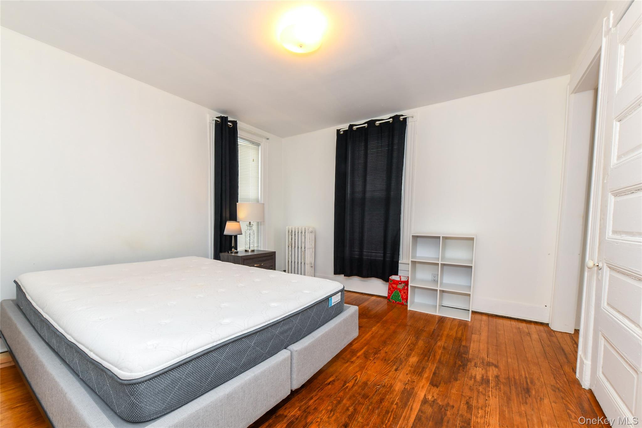 76-43 85th Road Queens, NY 11421 - Photo 23 of 31 a bedroom with a bed and wooden floor