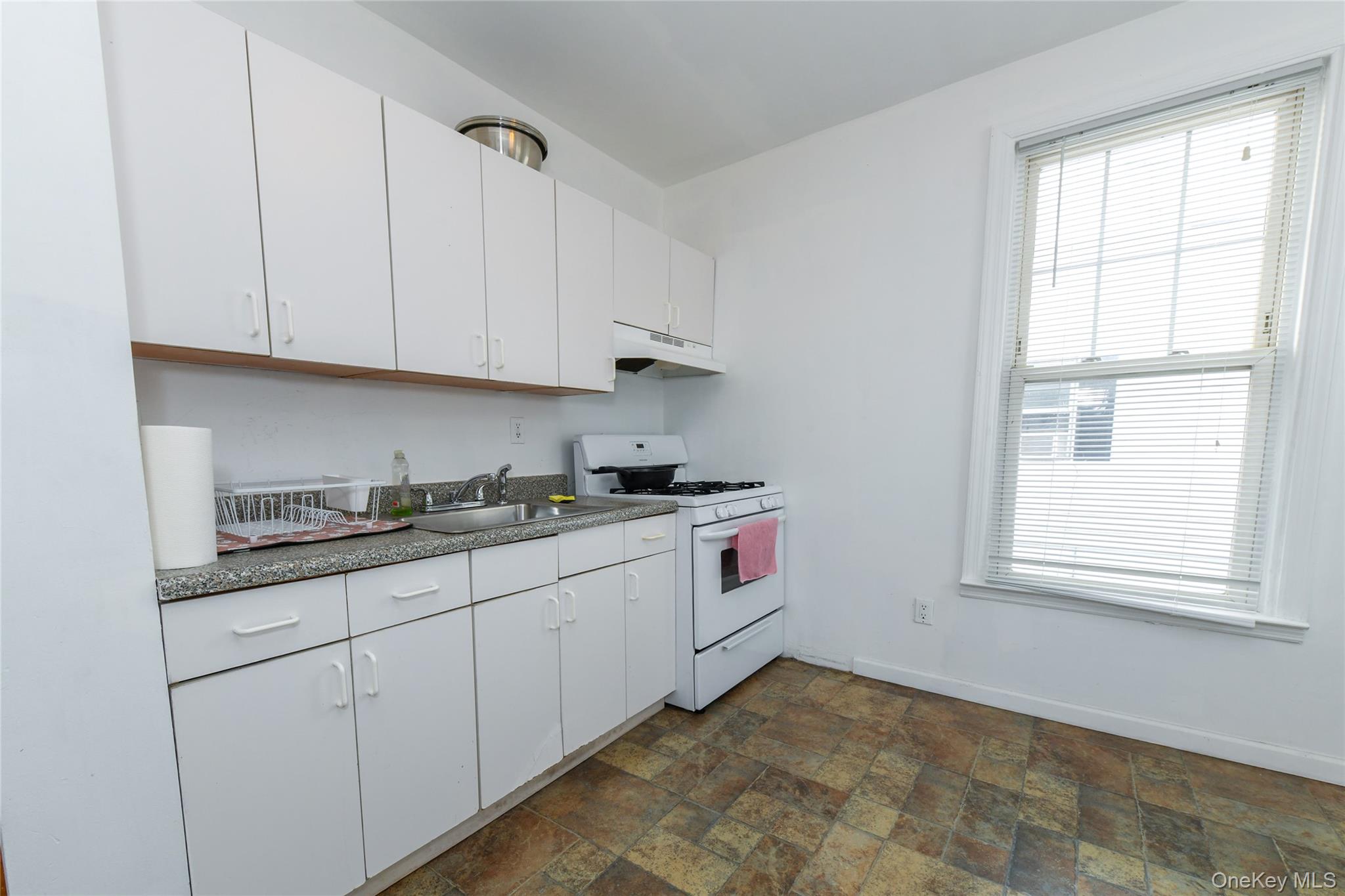 76-43 85th Road Queens, NY 11421 - Photo 25 of 31 a kitchen with granite countertop white cabinets and white appliances