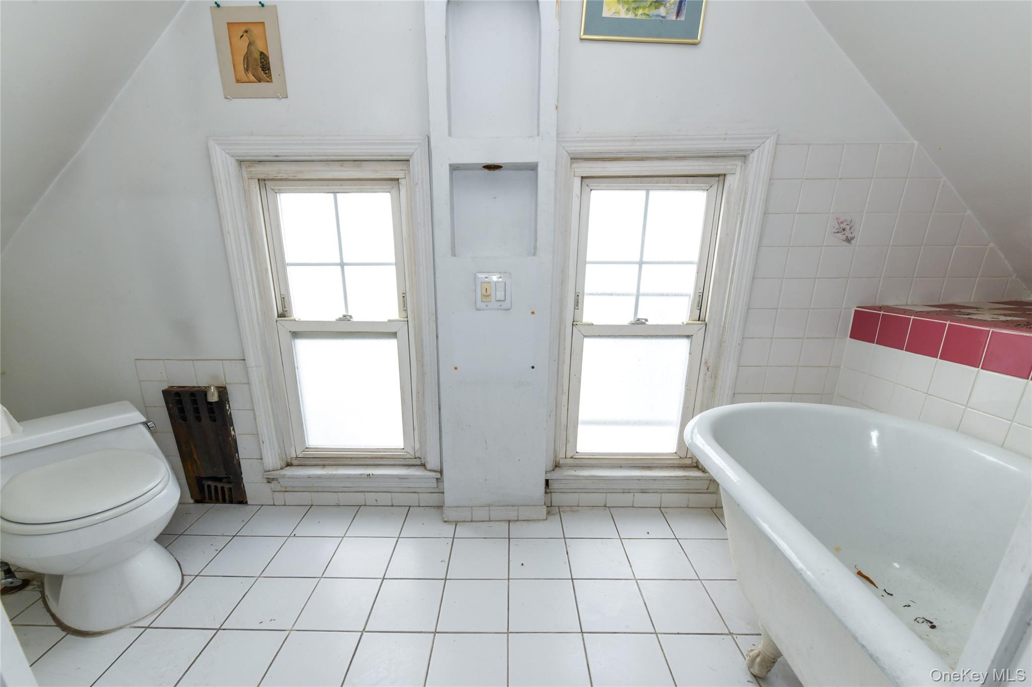 76-43 85th Road Queens, NY 11421 - Photo 26 of 31 a bathroom with a bathtub and window