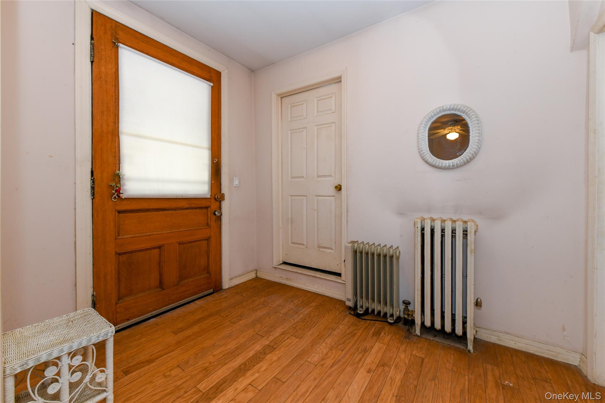 76-43 85th Road Queens, NY 11421 - Photo 7 of 31 a view of an empty room with wooden floor and a window